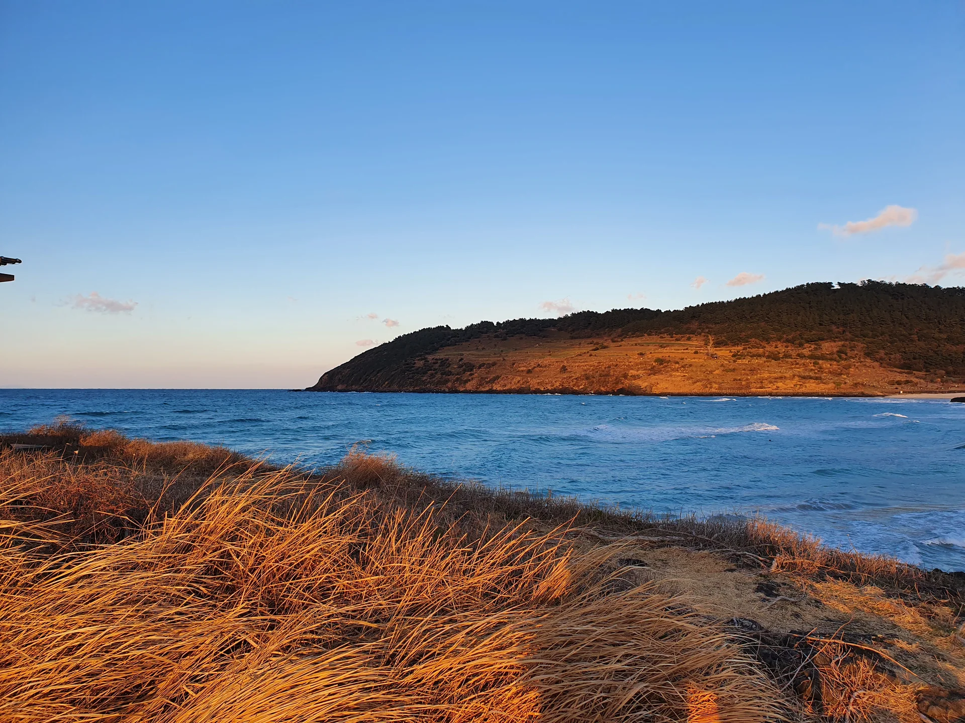 Bring the Korean coastline to your phone with these breathtaking ocean wallpapers. Korea is surrounded by water on three sides, and this collection captures it all — the turquoise shallows of Jeju's beaches, dramatic basalt cliffs plunging into the East Sea, tranquil fishing harbors at dawn, and endless Pacific horizons glowing under golden light.

These photos feature crashing waves against volcanic rock formations, serene island silhouettes at sunset, lighthouse beacons cutting through coastal fog, and the mirror-still surface of sheltered bays reflecting cotton-candy skies. Download these free Korean sea wallpapers for an aesthetic phone background that carries the calm and power of the ocean wherever you go., Jeju Island — Free Korean aesthetic wallpaper