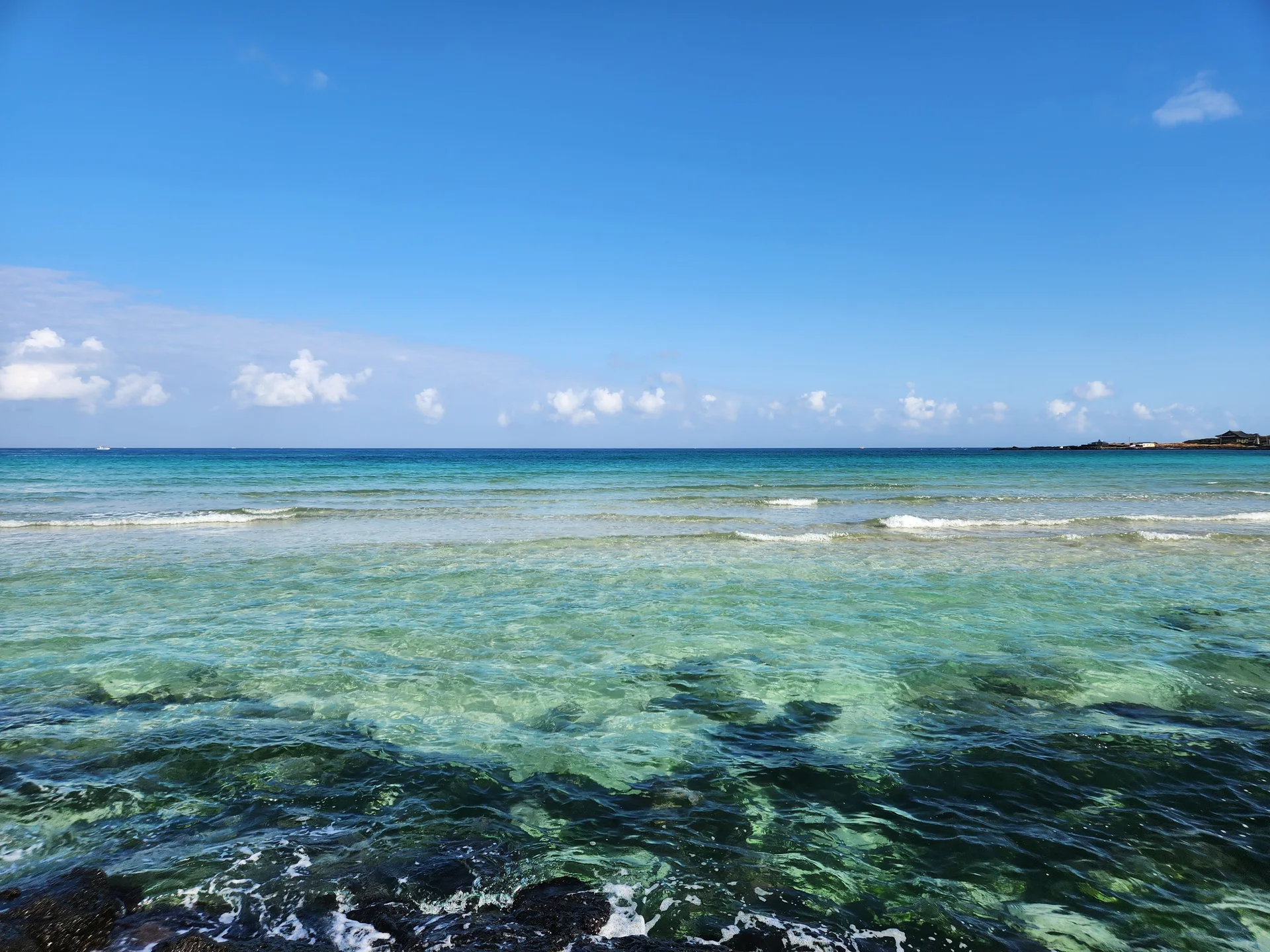 Bring the Korean coastline to your phone with these breathtaking ocean wallpapers. Korea is surrounded by water on three sides, and this collection captures it all — the turquoise shallows of Jeju's beaches, dramatic basalt cliffs plunging into the East Sea, tranquil fishing harbors at dawn, and endless Pacific horizons glowing under golden light.

These photos feature crashing waves against volcanic rock formations, serene island silhouettes at sunset, lighthouse beacons cutting through coastal fog, and the mirror-still surface of sheltered bays reflecting cotton-candy skies. Download these free Korean sea wallpapers for an aesthetic phone background that carries the calm and power of the ocean wherever you go., Haemajihaean-ro, Jeju — Free Korean aesthetic wallpaper