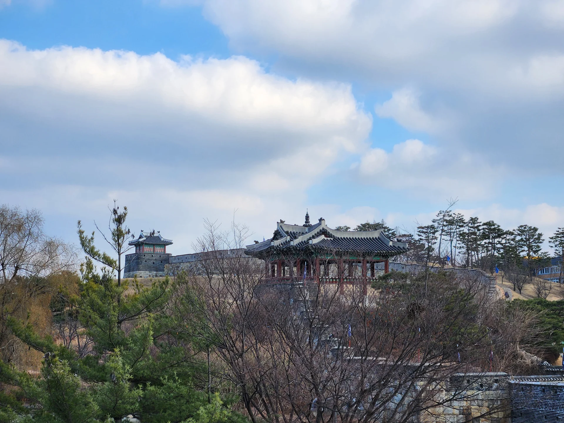 Explore Korea's architectural landscape through stunning phone wallpapers that span centuries of design. From the sleek glass curtain walls of Gangnam's skyscrapers to the raw concrete forms of brutalist apartment complexes, these images capture how Korea blends cutting-edge modernity with bold structural expression.

Look closer and you'll discover geometric patterns in subway station ceilings, sweeping curves of the Dongdaemun Design Plaza, and the quiet symmetry of traditional gate structures standing beside high-rises. Whether you're drawn to minimalist Korean design or dramatic urban geometry, these free aesthetic wallpapers transform your phone background into a gallery of architectural photography., Jeongjo-ro 906beon-gil, Buksu-dong, 팔달구, Suwon-si — Free Korean aesthetic wallpaper