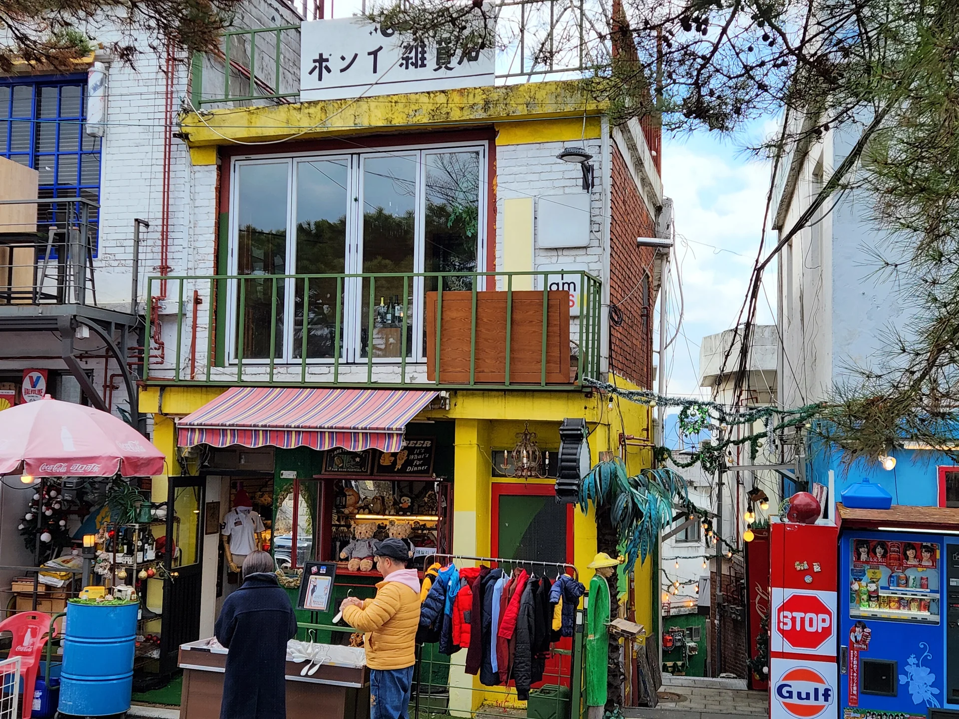 Experience the vibrant pulse of Korean city life through these dynamic street wallpapers. Bustling crosswalks in Myeongdong, colorful shop fronts in Hongdae, rain-slicked sidewalks reflecting neon signs, and everyday moments of commuters, street vendors, and cyclists moving through Seoul's urban rhythm — each image tells a story of a city constantly in motion.

Beyond Seoul, you'll find the charming streetscapes of Busan's hillside neighborhoods, the retro storefronts of Jeonju, and quiet residential lanes where laundry dries on balconies above parked scooters. These free Korean street wallpapers are perfect as an aesthetic phone background for anyone captivated by the raw energy and visual richness of Korean urban culture., Naksanseonggwakseo-gil, Ihwa-dong, Seoul — Free Korean aesthetic wallpaper