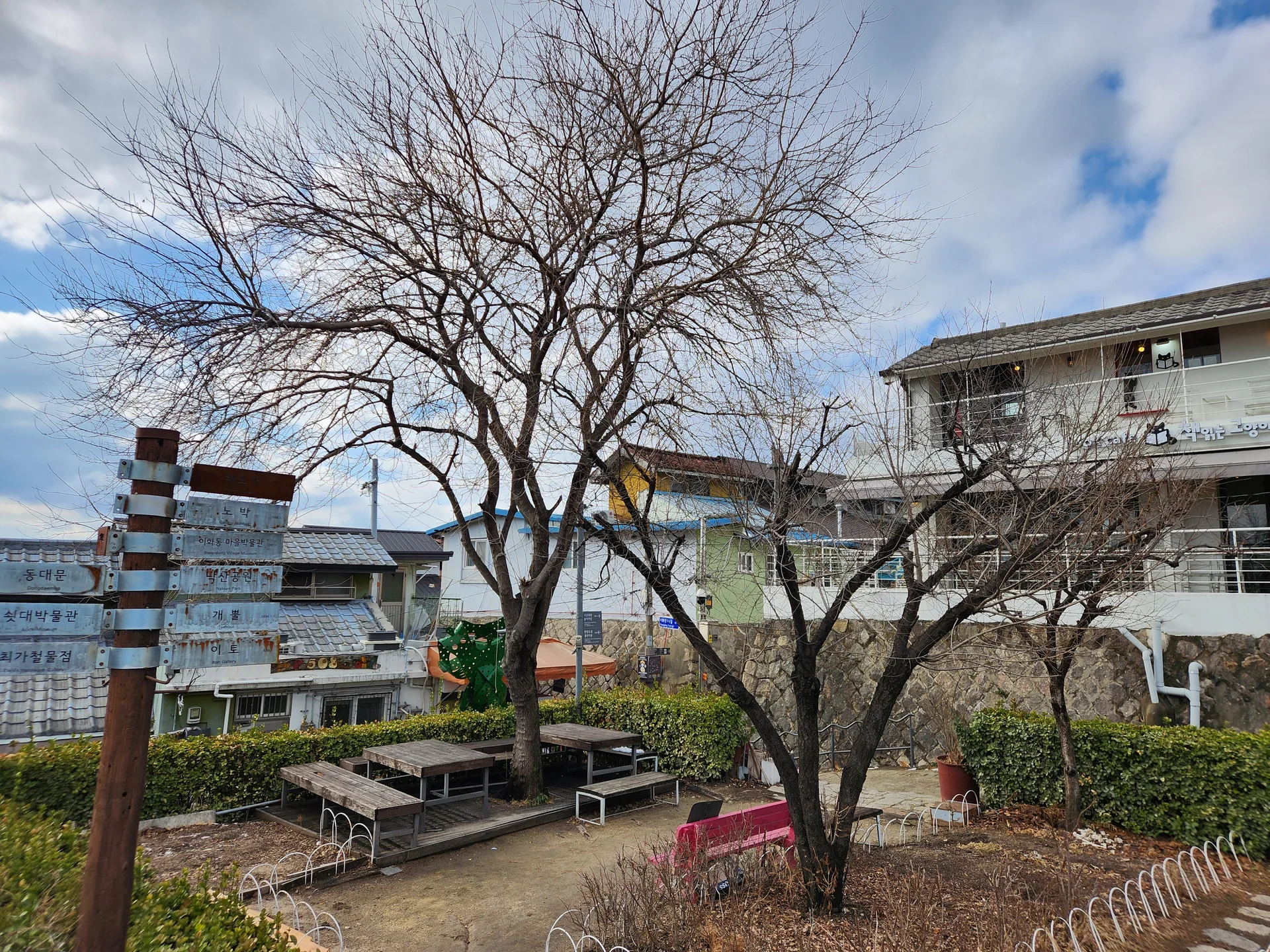 Experience the vibrant pulse of Korean city life through these dynamic street wallpapers. Bustling crosswalks in Myeongdong, colorful shop fronts in Hongdae, rain-slicked sidewalks reflecting neon signs, and everyday moments of commuters, street vendors, and cyclists moving through Seoul's urban rhythm — each image tells a story of a city constantly in motion.

Beyond Seoul, you'll find the charming streetscapes of Busan's hillside neighborhoods, the retro storefronts of Jeonju, and quiet residential lanes where laundry dries on balconies above parked scooters. These free Korean street wallpapers are perfect as an aesthetic phone background for anyone captivated by the raw energy and visual richness of Korean urban culture., Naksanseonggwakseo 1-gil, Ihwa-dong, Seoul — Free Korean aesthetic wallpaper