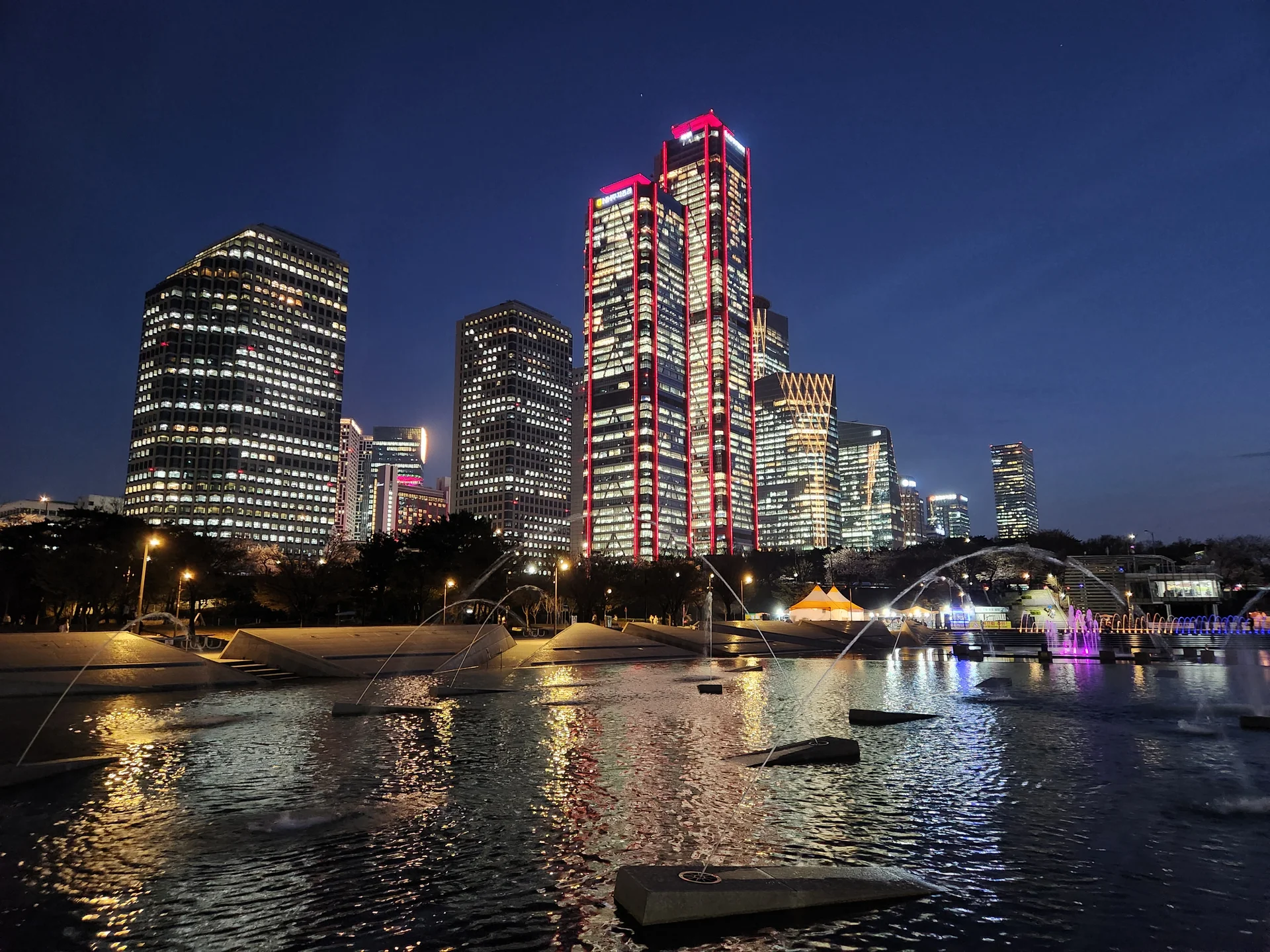 Light up your phone with the electric energy of Seoul after dark. These Korean nightscape wallpapers capture the city at its most cinematic — neon signage stacking up narrow alleyways, glowing street food stalls sending steam into cold night air, illuminated bridges spanning the Han River, and the shimmering towers of Gangnam reflected in rain-wet streets.

Seoul's nighttime personality is bold, colorful, and endlessly photogenic. You'll find the moody glow of Itaewon bars, the cyberpunk atmosphere of Euljiro's industrial blocks, and panoramic cityscapes from hilltop viewpoints where the city stretches to the horizon in every direction. Free download these aesthetic Seoul night wallpapers for a phone background that pulses with urban energy., Yeoui-dong, Seoul — Free Korean aesthetic wallpaper