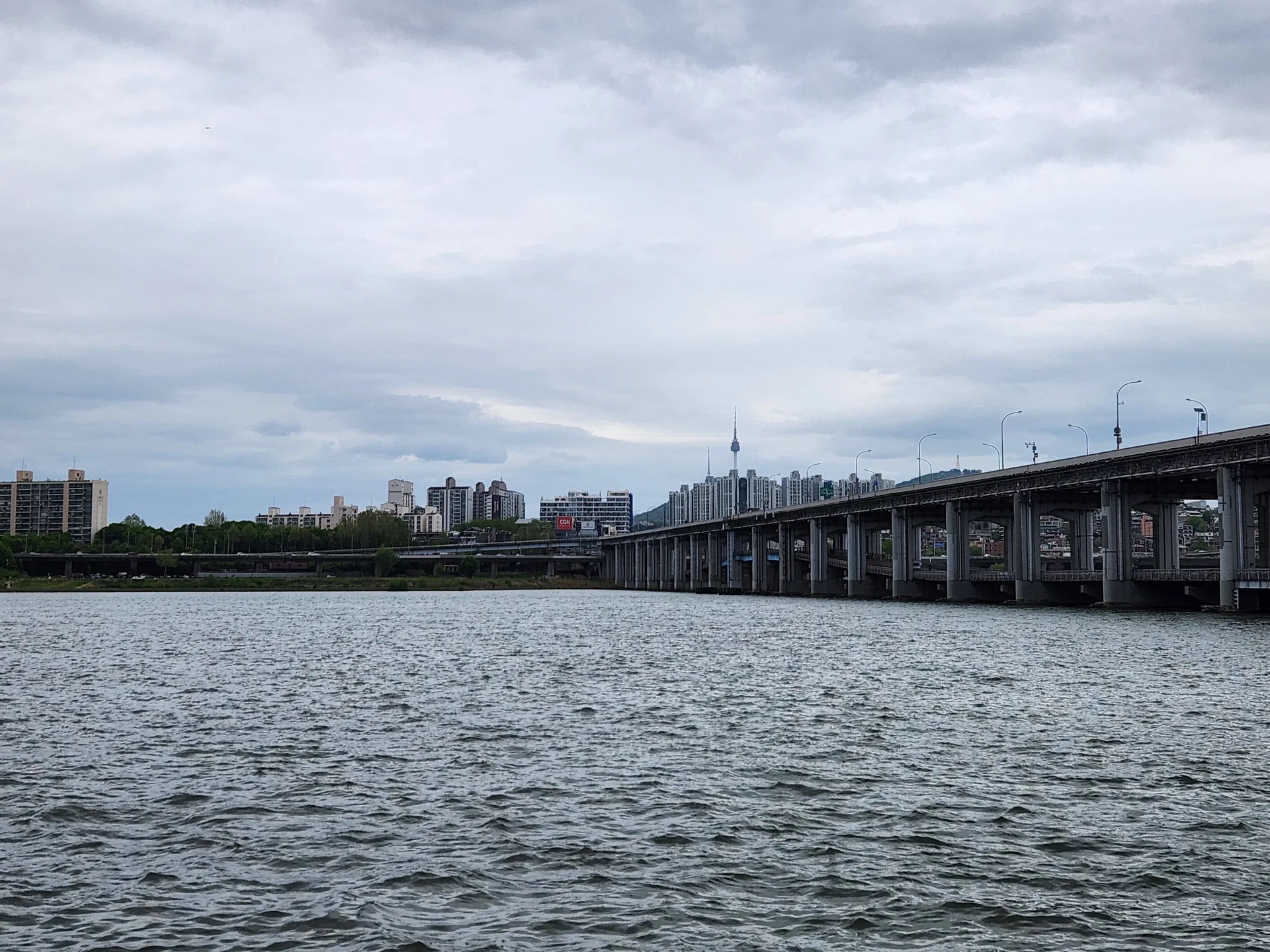 Bring the peaceful flow of Korea's waterways to your phone screen. These river wallpapers feature the iconic Han River cutting through Seoul's skyline, its surface mirroring city lights at dusk, as well as serene lakeside scenes from the countryside where mountains descend to meet still water and morning fog drifts across the surface.

From riverside cycling paths lined with cherry blossoms to dramatic reflections of autumn foliage in mountain streams, each image captures the calming presence of water in Korean landscapes. Waterfront pavilions, stone bridges arching over gentle currents, and lone boats floating in golden light are all waiting here. Download these free Korean river wallpapers for an aesthetic phone background full of tranquility., Banpodaero, Banpo 2(i)-dong, Seoul — Free Korean aesthetic wallpaper