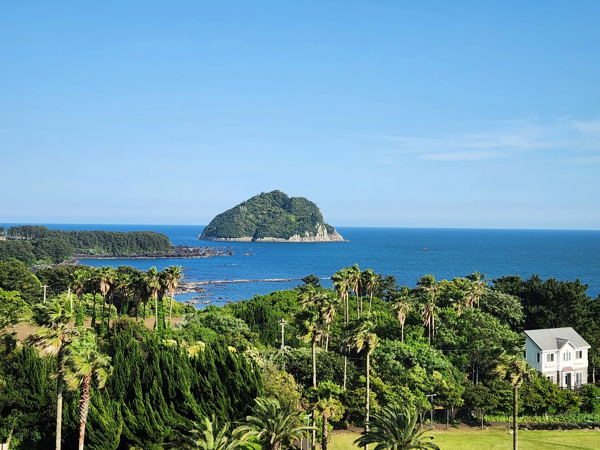 Bring the Korean coastline to your phone with these breathtaking ocean wallpapers. Korea is surrounded by water on three sides, and this collection captures it all — the turquoise shallows of Jeju's beaches, dramatic basalt cliffs plunging into the East Sea, tranquil fishing harbors at dawn, and endless Pacific horizons glowing under golden light.

These photos feature crashing waves against volcanic rock formations, serene island silhouettes at sunset, lighthouse beacons cutting through coastal fog, and the mirror-still surface of sheltered bays reflecting cotton-candy skies. Download these free Korean sea wallpapers for an aesthetic phone background that carries the calm and power of the ocean wherever you go., Songsan-dong, Seogwipo-si — Free Korean aesthetic wallpaper