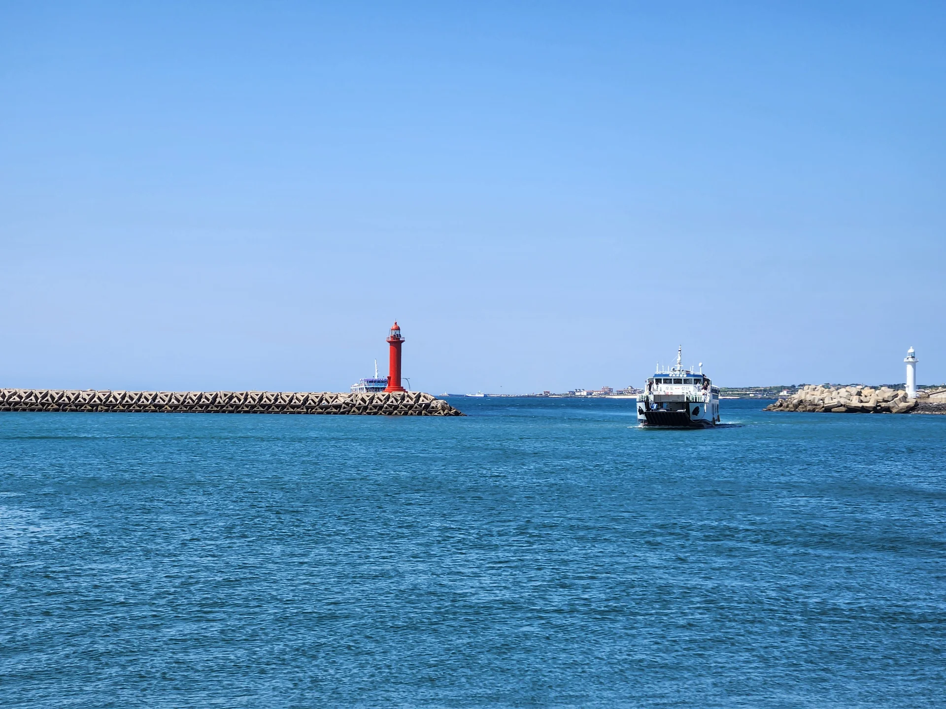 Bring the Korean coastline to your phone with these breathtaking ocean wallpapers. Korea is surrounded by water on three sides, and this collection captures it all — the turquoise shallows of Jeju's beaches, dramatic basalt cliffs plunging into the East Sea, tranquil fishing harbors at dawn, and endless Pacific horizons glowing under golden light.

These photos feature crashing waves against volcanic rock formations, serene island silhouettes at sunset, lighthouse beacons cutting through coastal fog, and the mirror-still surface of sheltered bays reflecting cotton-candy skies. Download these free Korean sea wallpapers for an aesthetic phone background that carries the calm and power of the ocean wherever you go., Seongsandeungyong-ro, Seogwipo-si — Free Korean aesthetic wallpaper