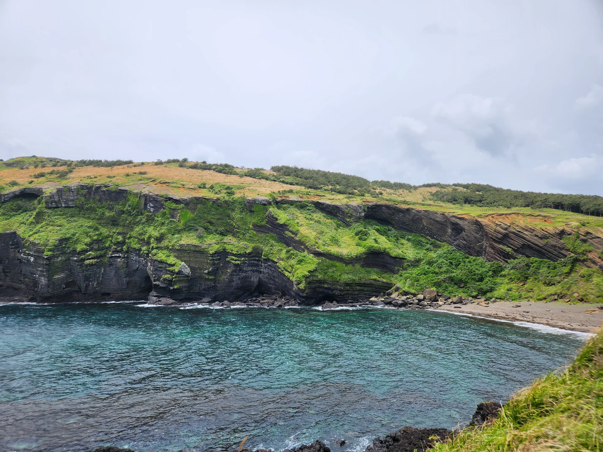 Immerse your screen in the untouched beauty of Korea's natural world. These Korean wallpapers feature sweeping countryside fields blanketed in green, hidden valleys where morning mist clings to the hillsides, and winding streams cutting through rocky terrain. Each photo captures the raw, peaceful energy that makes Korea's landscapes so distinctive.

From the volcanic plains of Jeju Island to the lush wetlands of Suncheon Bay, this collection showcases nature in every mood — dramatic storm clouds rolling over ridgelines, golden sunlight filtering through canopy gaps, and wildflower meadows stretching toward distant peaks. Download these aesthetic phone backgrounds for free and bring a moment of Korean tranquility to your daily life., Udohaean-gil, Jeju — Free Korean aesthetic wallpaper