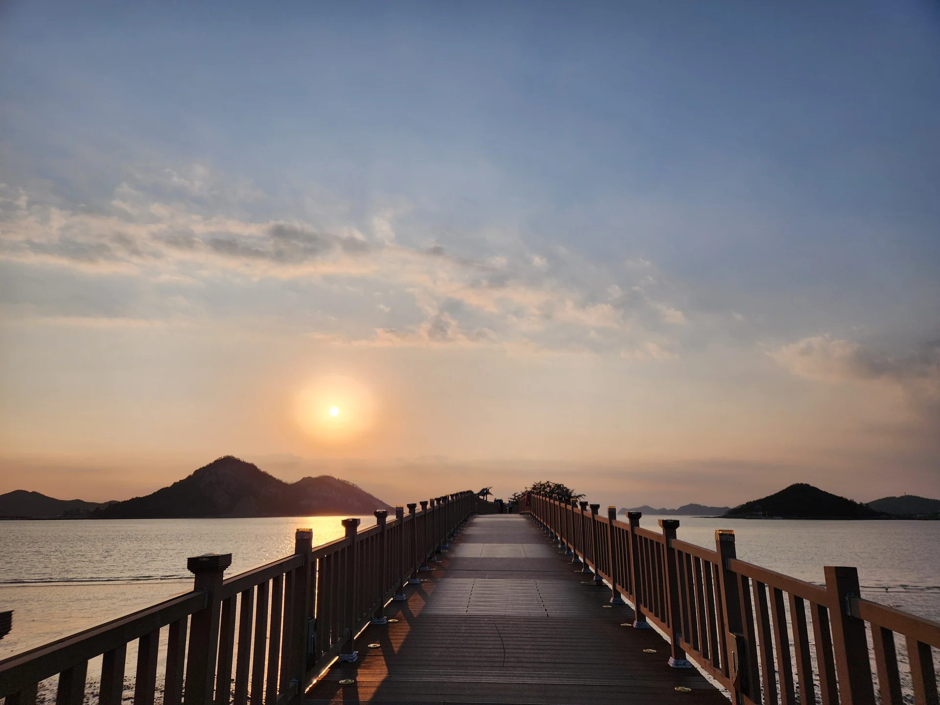 Bring the Korean coastline to your phone with these breathtaking ocean wallpapers. Korea is surrounded by water on three sides, and this collection captures it all — the turquoise shallows of Jeju's beaches, dramatic basalt cliffs plunging into the East Sea, tranquil fishing harbors at dawn, and endless Pacific horizons glowing under golden light.

These photos feature crashing waves against volcanic rock formations, serene island silhouettes at sunset, lighthouse beacons cutting through coastal fog, and the mirror-still surface of sheltered bays reflecting cotton-candy skies. Download these free Korean sea wallpapers for an aesthetic phone background that carries the calm and power of the ocean wherever you go., Seonyudo 1-gil, Gunsan-si — Free Korean aesthetic wallpaper