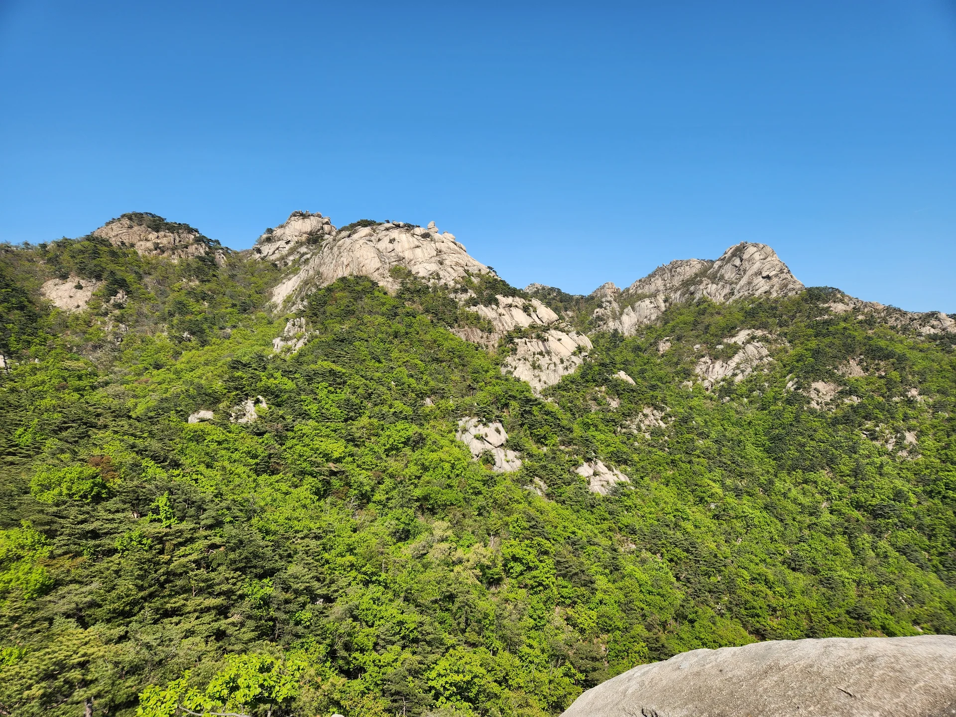 Set your phone against the majestic backdrop of Korea's mountain ranges. The Korean peninsula is nearly 70% mountainous, and these wallpapers celebrate that dramatic terrain — jagged granite peaks rising above the clouds, ancient fortress walls tracing ridgelines, and forest trails disappearing into autumn-colored valleys.

From the iconic rocky summits of Bukhansan in Seoul to the remote alpine meadows of Seoraksan, each image captures the scale and serenity of Korean mountain landscapes across all four seasons. Snow-dusted winter peaks, spring azalea blooms on hillsides, summer greenery, and fiery fall foliage are all here. Free download these aesthetic mountain wallpapers and carry Korea's highland grandeur in your pocket., 통천문, Pyeongchang-dong, Seoul — Free Korean aesthetic wallpaper
