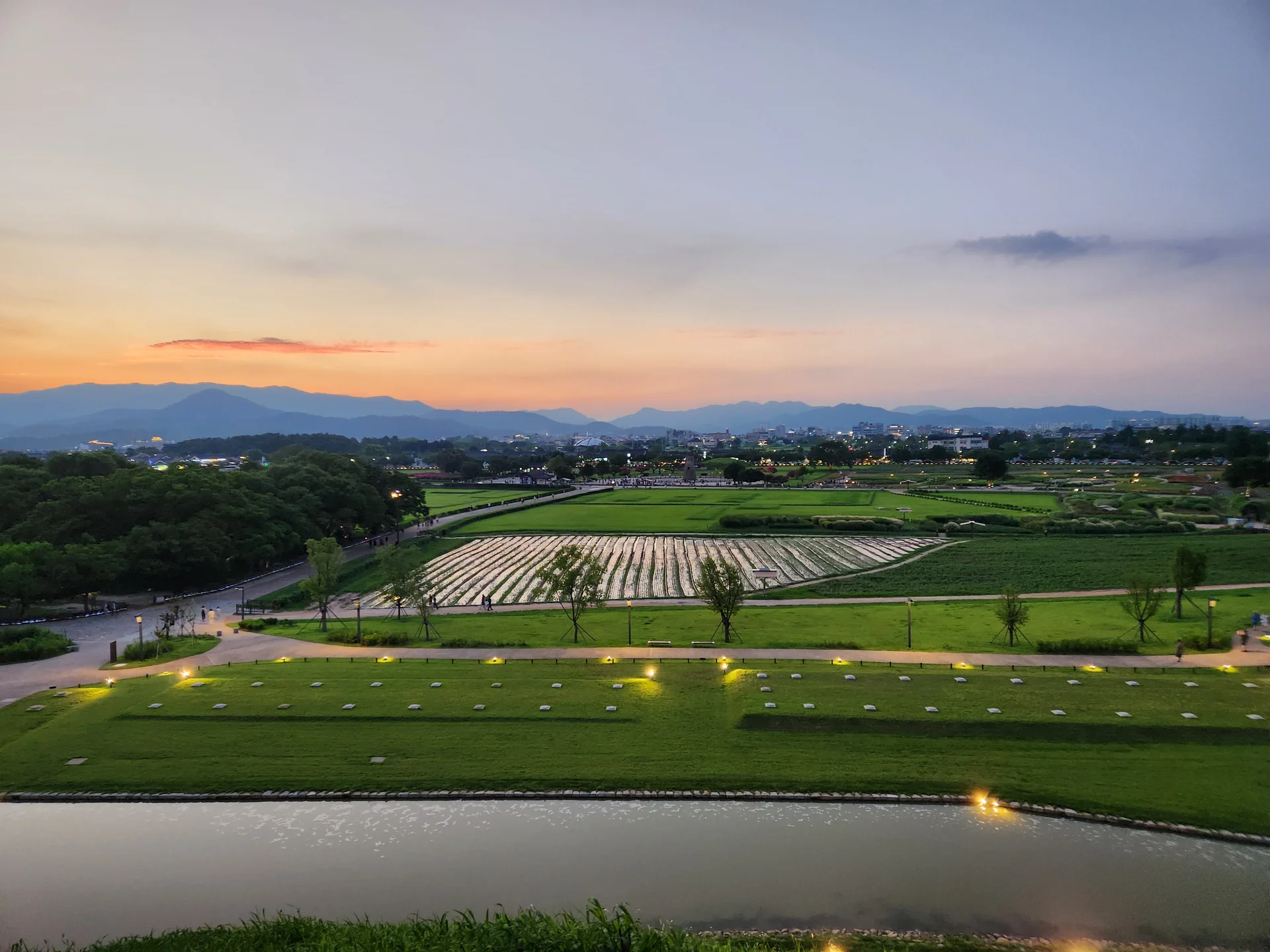 Transform your phone with the inviting green spaces of Korea's parks and gardens. From the sprawling lawns of Olympic Park in Seoul to the meticulously landscaped botanical gardens of the southern coast, these wallpapers capture the beauty of Korea's curated natural spaces — blooming flower beds, reflective lotus ponds, tree-lined promenades, and autumn foliage canopies.

Korean parks are designed for contemplation, and it shows in every image: stone pathways curving around still water, wooden pavilions framed by seasonal color, cherry-blossom tunnels creating pink corridors, and wide meadows where families gather under open skies. Free download these aesthetic park wallpapers and give your phone background the refreshing energy of a Korean garden escape., Inwang-dong, Wolseong-dong, Gyeongju-si — Free Korean aesthetic wallpaper