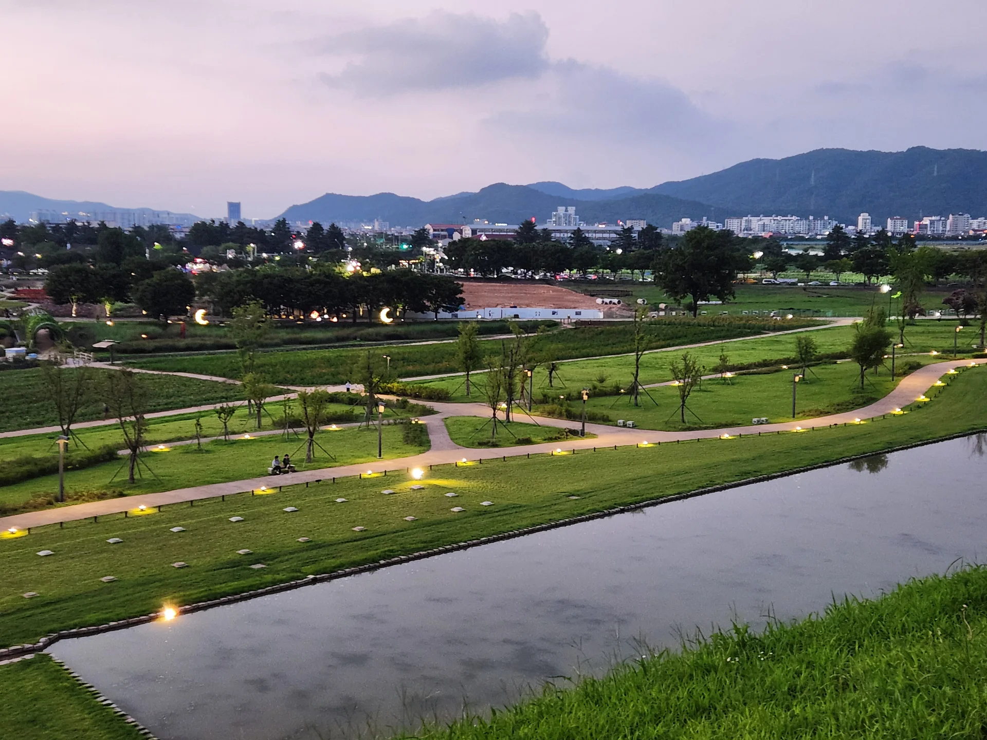 Transform your phone with the inviting green spaces of Korea's parks and gardens. From the sprawling lawns of Olympic Park in Seoul to the meticulously landscaped botanical gardens of the southern coast, these wallpapers capture the beauty of Korea's curated natural spaces — blooming flower beds, reflective lotus ponds, tree-lined promenades, and autumn foliage canopies.

Korean parks are designed for contemplation, and it shows in every image: stone pathways curving around still water, wooden pavilions framed by seasonal color, cherry-blossom tunnels creating pink corridors, and wide meadows where families gather under open skies. Free download these aesthetic park wallpapers and give your phone background the refreshing energy of a Korean garden escape., Iljeong-ro, Guhwang-dong, Wolseong-dong, Gyeongju-si — Free Korean aesthetic wallpaper