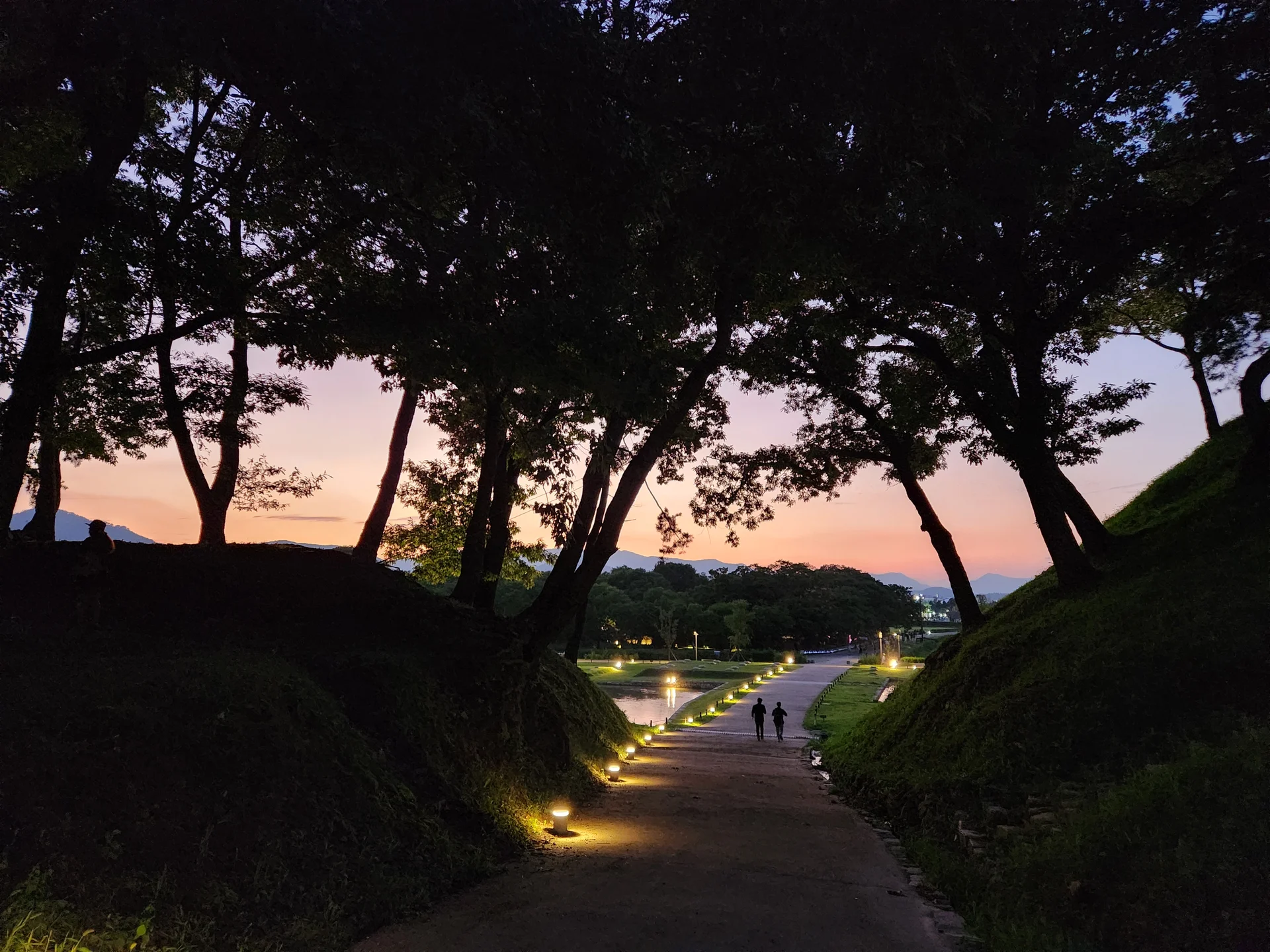 Transform your phone with the inviting green spaces of Korea's parks and gardens. From the sprawling lawns of Olympic Park in Seoul to the meticulously landscaped botanical gardens of the southern coast, these wallpapers capture the beauty of Korea's curated natural spaces — blooming flower beds, reflective lotus ponds, tree-lined promenades, and autumn foliage canopies.

Korean parks are designed for contemplation, and it shows in every image: stone pathways curving around still water, wooden pavilions framed by seasonal color, cherry-blossom tunnels creating pink corridors, and wide meadows where families gather under open skies. Free download these aesthetic park wallpapers and give your phone background the refreshing energy of a Korean garden escape., Inwang-dong, Wolseong-dong, Gyeongju-si — Free Korean aesthetic wallpaper