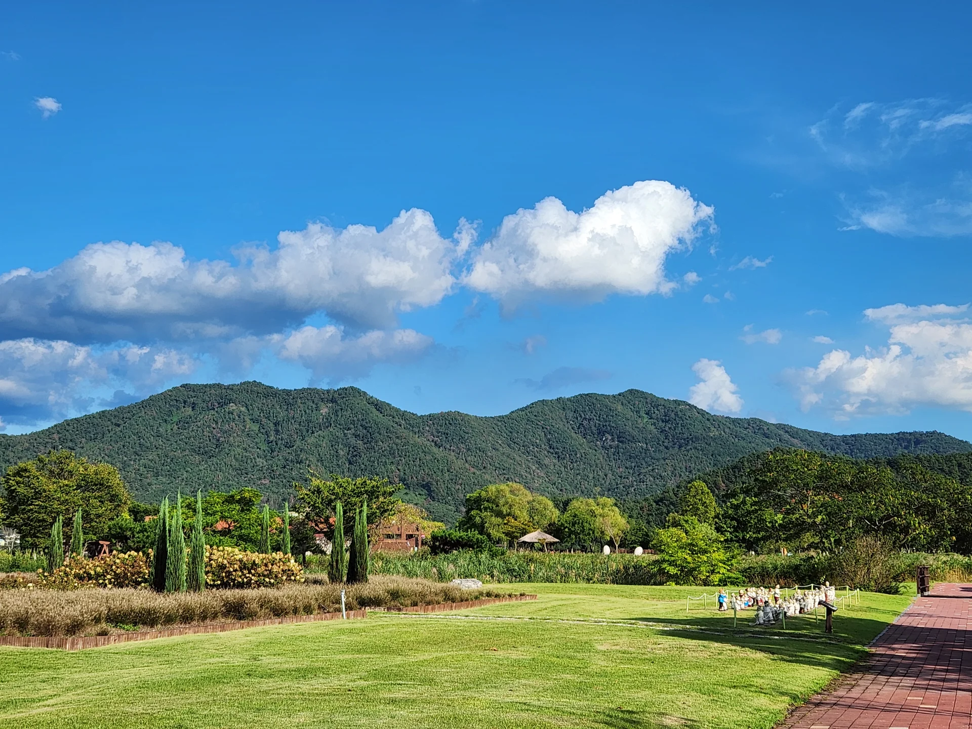 Immerse your screen in the untouched beauty of Korea's natural world. These Korean wallpapers feature sweeping countryside fields blanketed in green, hidden valleys where morning mist clings to the hillsides, and winding streams cutting through rocky terrain. Each photo captures the raw, peaceful energy that makes Korea's landscapes so distinctive.

From the volcanic plains of Jeju Island to the lush wetlands of Suncheon Bay, this collection showcases nature in every mood — dramatic storm clouds rolling over ridgelines, golden sunlight filtering through canopy gaps, and wildflower meadows stretching toward distant peaks. Download these aesthetic phone backgrounds for free and bring a moment of Korean tranquility to your daily life., Seonhak-ri, Daedae-dong, Suncheon-si — Free Korean aesthetic wallpaper