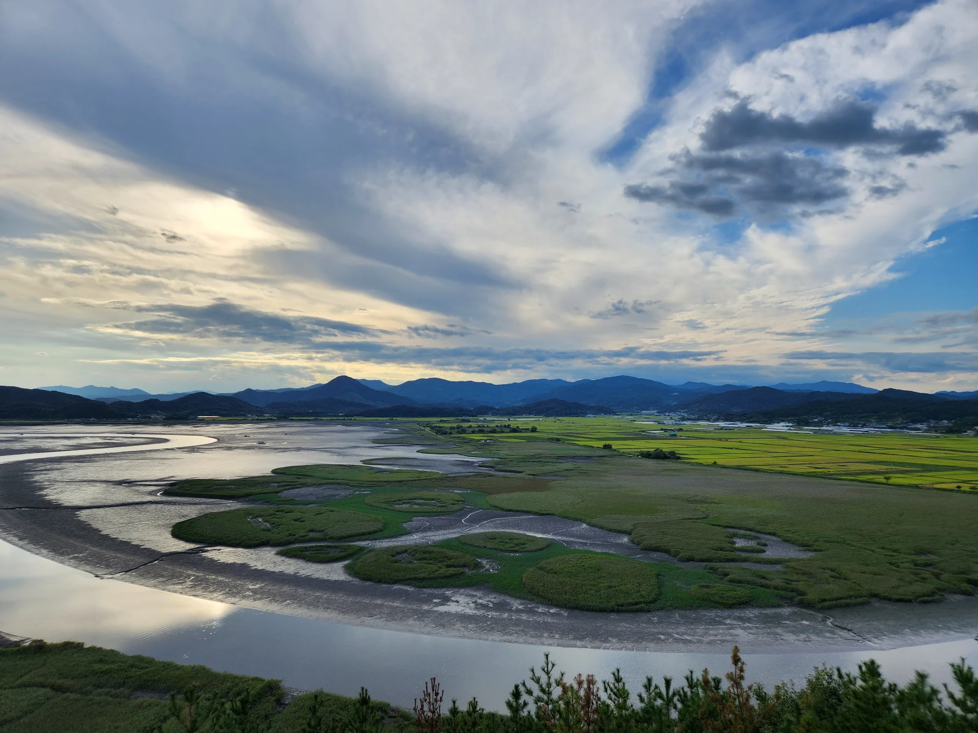 Immerse your screen in the untouched beauty of Korea's natural world. These Korean wallpapers feature sweeping countryside fields blanketed in green, hidden valleys where morning mist clings to the hillsides, and winding streams cutting through rocky terrain. Each photo captures the raw, peaceful energy that makes Korea's landscapes so distinctive.

From the volcanic plains of Jeju Island to the lush wetlands of Suncheon Bay, this collection showcases nature in every mood — dramatic storm clouds rolling over ridgelines, golden sunlight filtering through canopy gaps, and wildflower meadows stretching toward distant peaks. Download these aesthetic phone backgrounds for free and bring a moment of Korean tranquility to your daily life., Suncheon-si — Free Korean aesthetic wallpaper