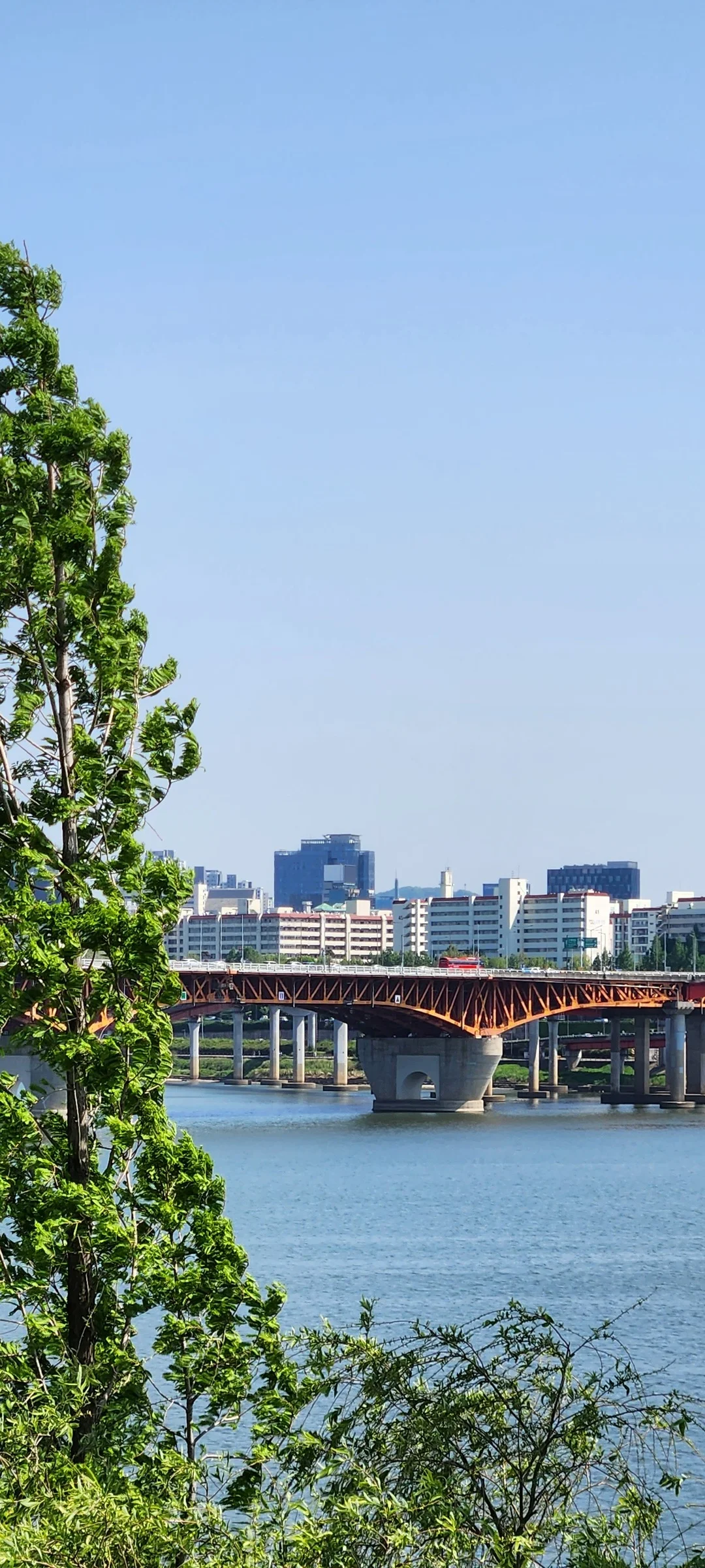 Bring the peaceful flow of Korea's waterways to your phone screen. These river wallpapers feature the iconic Han River cutting through Seoul's skyline, its surface mirroring city lights at dusk, as well as serene lakeside scenes from the countryside where mountains descend to meet still water and morning fog drifts across the surface.

From riverside cycling paths lined with cherry blossoms to dramatic reflections of autumn foliage in mountain streams, each image captures the calming presence of water in Korean landscapes. Waterfront pavilions, stone bridges arching over gentle currents, and lone boats floating in golden light are all waiting here. Download these free Korean river wallpapers for an aesthetic phone background full of tranquility., Gangbyeonbuk-ro, Seongsu 1(il)-ga 1(il)-dong, Seoul — Free Korean aesthetic wallpaper