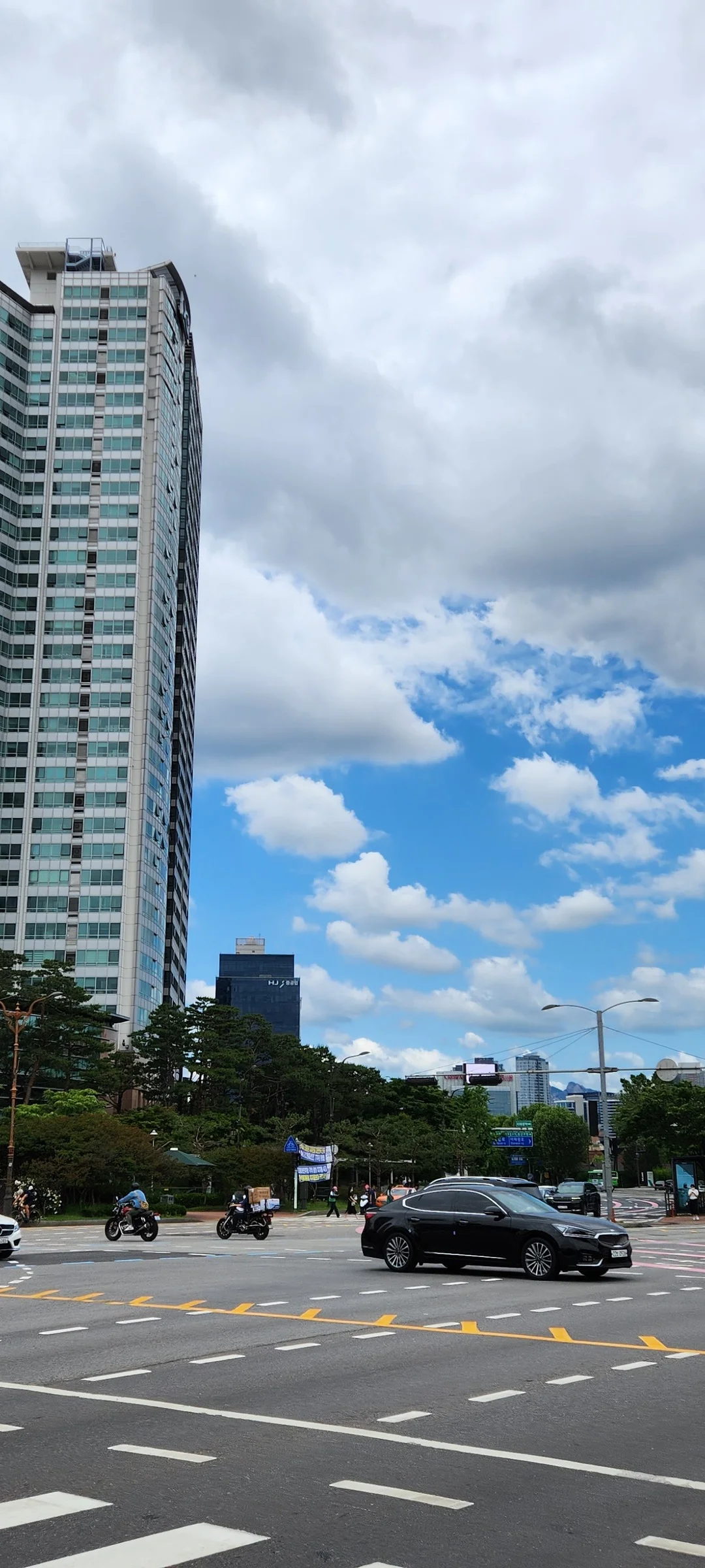 Experience the vibrant pulse of Korean city life through these dynamic street wallpapers. Bustling crosswalks in Myeongdong, colorful shop fronts in Hongdae, rain-slicked sidewalks reflecting neon signs, and everyday moments of commuters, street vendors, and cyclists moving through Seoul's urban rhythm — each image tells a story of a city constantly in motion.

Beyond Seoul, you'll find the charming streetscapes of Busan's hillside neighborhoods, the retro storefronts of Jeonju, and quiet residential lanes where laundry dries on balconies above parked scooters. These free Korean street wallpapers are perfect as an aesthetic phone background for anyone captivated by the raw energy and visual richness of Korean urban culture., Hangang-daero, Hangangno-dong, Seoul — Free Korean aesthetic wallpaper