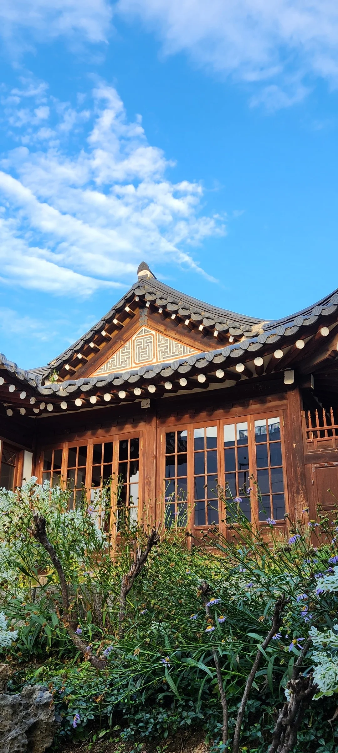 Adorn your phone with the timeless elegance of hanok, Korea's traditional wooden houses. These wallpapers showcase the graceful curved rooflines, hand-carved wooden lattice doors, and serene inner courtyards that have defined Korean residential architecture for centuries. Preserved hanok villages in Bukchon and Jeonju offer a living window into Korea's past.

Each image reveals the quiet beauty of these heritage homes — clay walls weathered to warm earth tones, dark timber frames contrasting with paper-screened windows, stone foundations meeting manicured courtyard gardens, and traditional eaves silhouetted against modern skylines. Download these free hanok wallpapers for an aesthetic phone background that celebrates the harmony between Korean tradition and contemporary life., Bukchon-ro, Gahoe-dong, Seoul — Free Korean aesthetic wallpaper