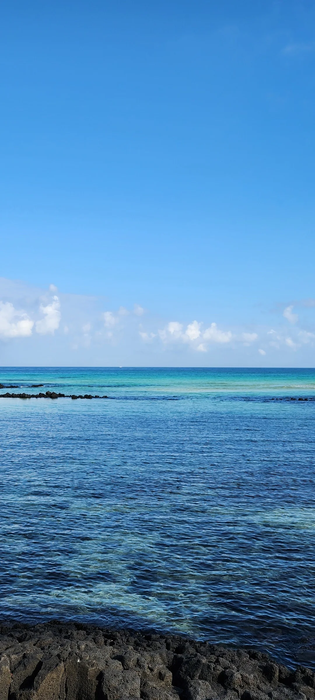 Bring the Korean coastline to your phone with these breathtaking ocean wallpapers. Korea is surrounded by water on three sides, and this collection captures it all — the turquoise shallows of Jeju's beaches, dramatic basalt cliffs plunging into the East Sea, tranquil fishing harbors at dawn, and endless Pacific horizons glowing under golden light.

These photos feature crashing waves against volcanic rock formations, serene island silhouettes at sunset, lighthouse beacons cutting through coastal fog, and the mirror-still surface of sheltered bays reflecting cotton-candy skies. Download these free Korean sea wallpapers for an aesthetic phone background that carries the calm and power of the ocean wherever you go., Haemajihaean-ro, Jeju — Free Korean aesthetic wallpaper