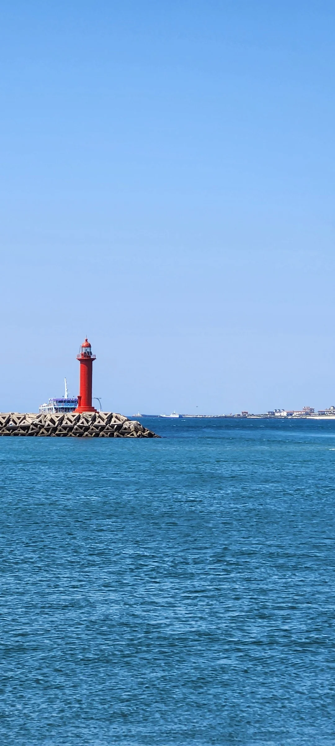 Bring the Korean coastline to your phone with these breathtaking ocean wallpapers. Korea is surrounded by water on three sides, and this collection captures it all — the turquoise shallows of Jeju's beaches, dramatic basalt cliffs plunging into the East Sea, tranquil fishing harbors at dawn, and endless Pacific horizons glowing under golden light.

These photos feature crashing waves against volcanic rock formations, serene island silhouettes at sunset, lighthouse beacons cutting through coastal fog, and the mirror-still surface of sheltered bays reflecting cotton-candy skies. Download these free Korean sea wallpapers for an aesthetic phone background that carries the calm and power of the ocean wherever you go., Seongsandeungyong-ro, Seogwipo-si — Free Korean aesthetic wallpaper