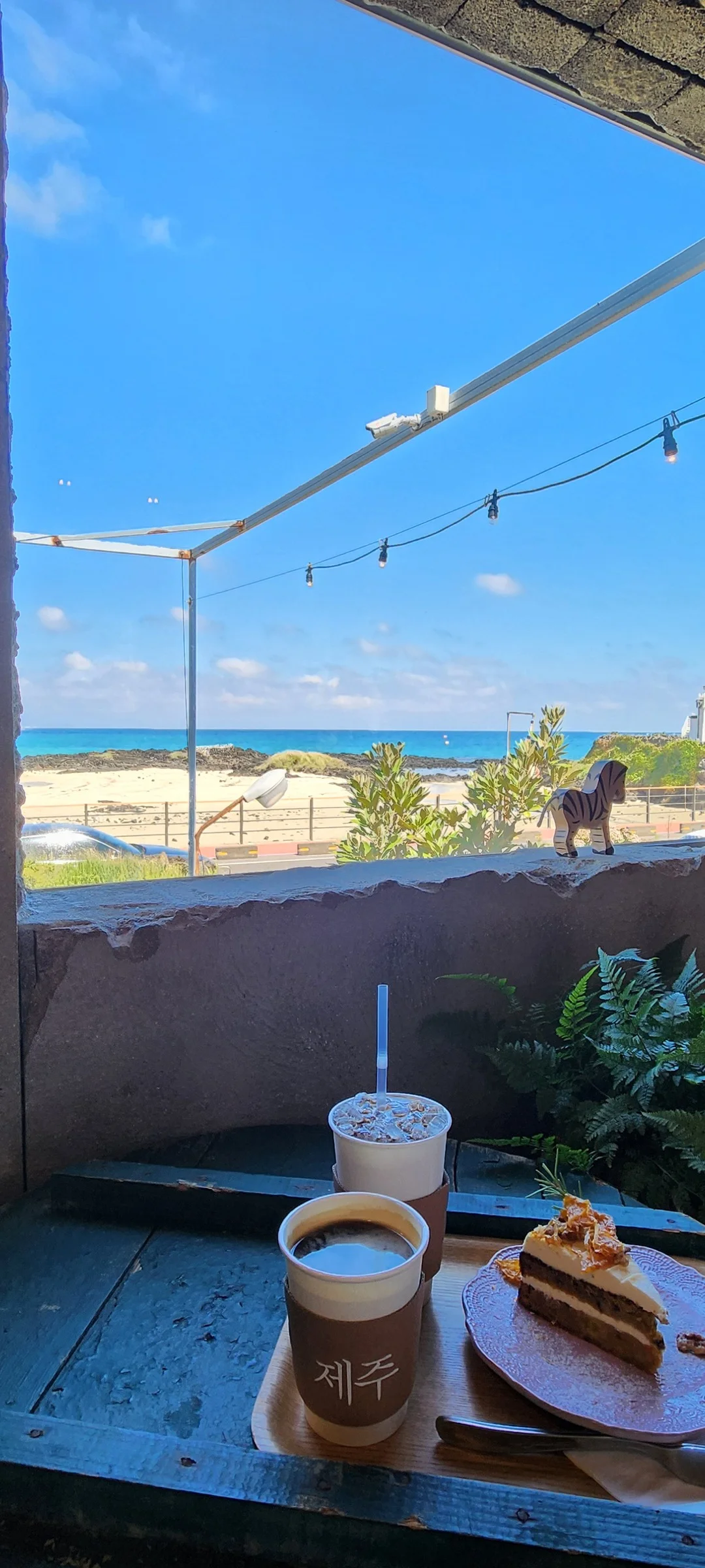 Wrap your phone in the cozy, Instagram-worthy atmosphere of Korean cafe culture. Korea's cafes are more than coffee shops — they're design experiences. These wallpapers feature warm interior light falling on minimalist wooden counters, perfectly crafted latte art in handmade ceramic cups, floor-to-ceiling windows overlooking quiet streets, and rooftop terraces with city panoramas.

From industrial-chic converted warehouses in Seongsu to tiny hidden basement cafes in Ikseon-dong, each image captures the aesthetic sensibility that makes Korean cafe design world-famous. Trailing plants, warm Edison bulbs, curated book walls, and the soft golden glow of afternoon light create scenes you'll want to stare at. Download these free Korean cafe wallpapers for a phone background that feels like a warm hug., 면수1길, Jeju — Free Korean aesthetic wallpaper