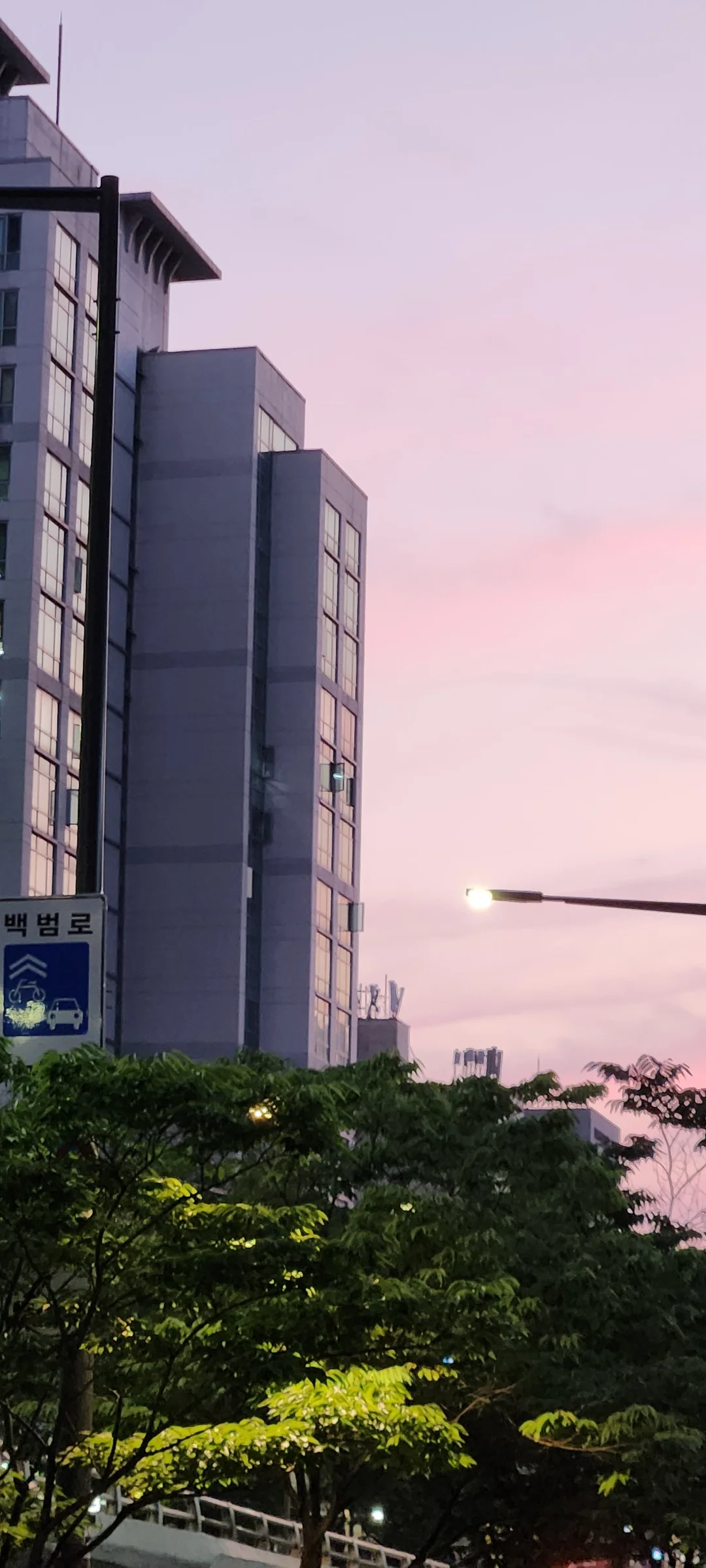 Experience the vibrant pulse of Korean city life through these dynamic street wallpapers. Bustling crosswalks in Myeongdong, colorful shop fronts in Hongdae, rain-slicked sidewalks reflecting neon signs, and everyday moments of commuters, street vendors, and cyclists moving through Seoul's urban rhythm — each image tells a story of a city constantly in motion.

Beyond Seoul, you'll find the charming streetscapes of Busan's hillside neighborhoods, the retro storefronts of Jeonju, and quiet residential lanes where laundry dries on balconies above parked scooters. These free Korean street wallpapers are perfect as an aesthetic phone background for anyone captivated by the raw energy and visual richness of Korean urban culture., Cheongpa-ro, Wonhyoro 1(iI)-dong, Seoul — Free Korean aesthetic wallpaper