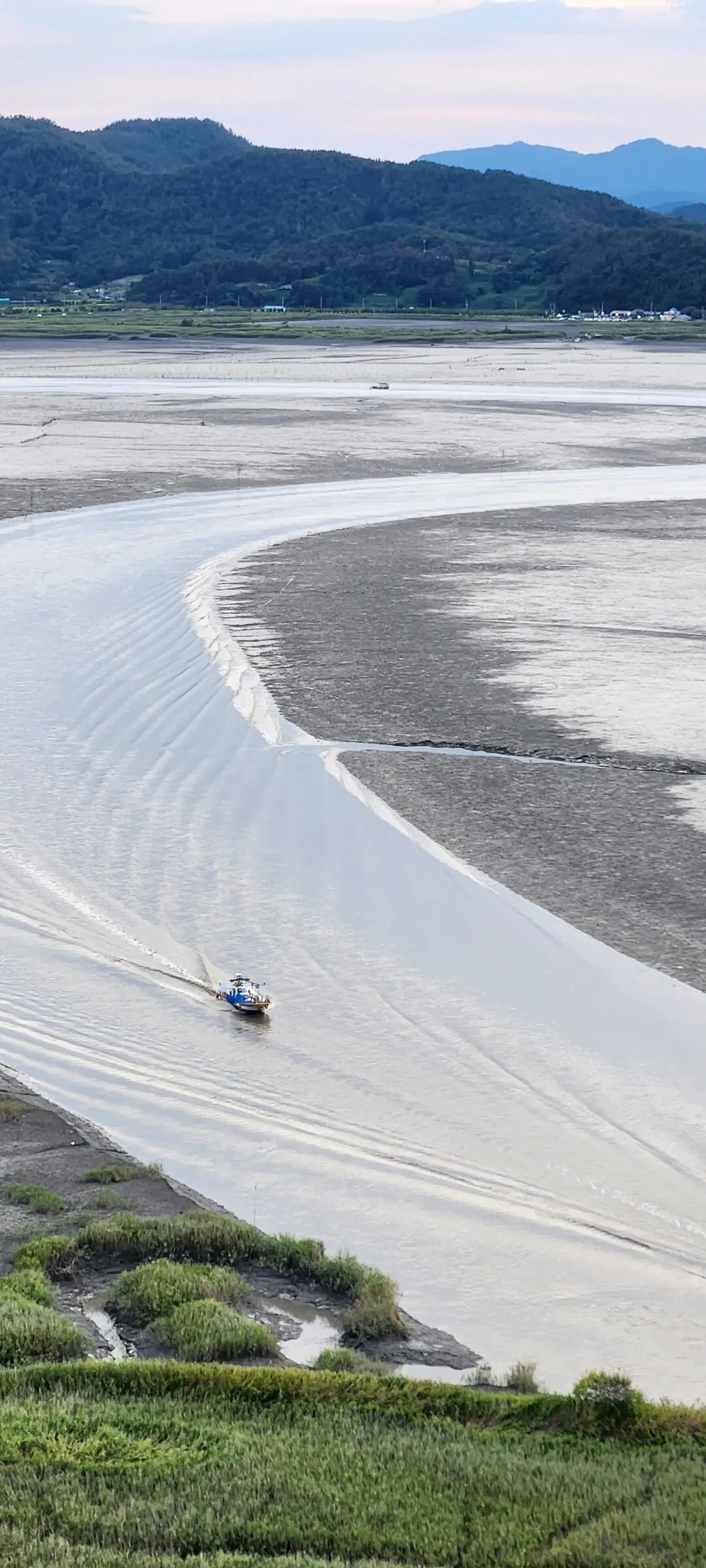 Immerse your screen in the untouched beauty of Korea's natural world. These Korean wallpapers feature sweeping countryside fields blanketed in green, hidden valleys where morning mist clings to the hillsides, and winding streams cutting through rocky terrain. Each photo captures the raw, peaceful energy that makes Korea's landscapes so distinctive.

From the volcanic plains of Jeju Island to the lush wetlands of Suncheon Bay, this collection showcases nature in every mood — dramatic storm clouds rolling over ridgelines, golden sunlight filtering through canopy gaps, and wildflower meadows stretching toward distant peaks. Download these aesthetic phone backgrounds for free and bring a moment of Korean tranquility to your daily life., Suncheon-si — Free Korean aesthetic wallpaper