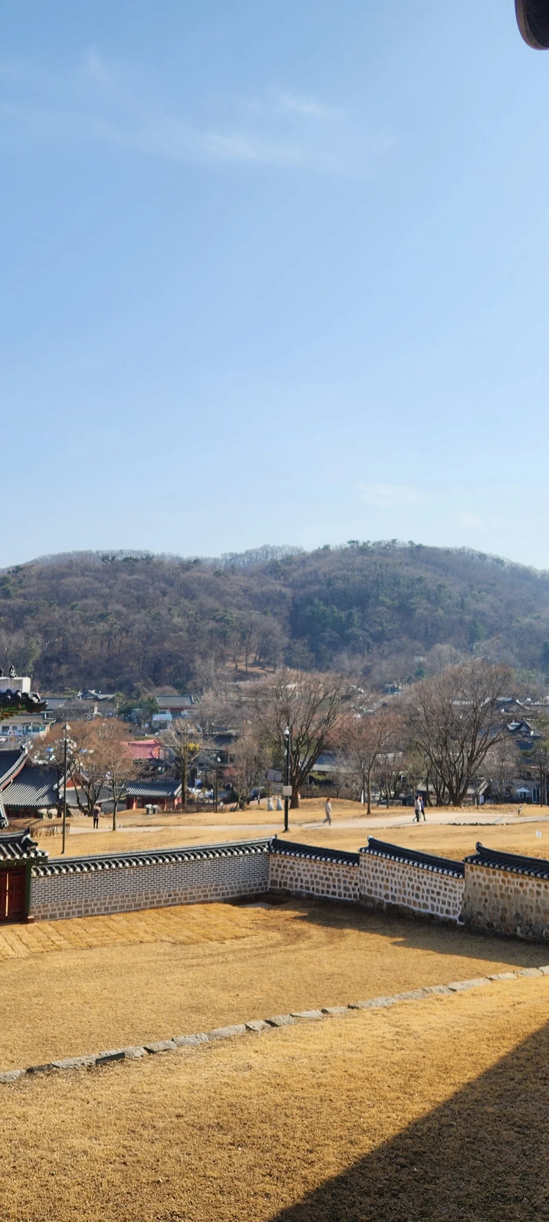 Adorn your phone with the timeless elegance of hanok, Korea's traditional wooden houses. These wallpapers showcase the graceful curved rooflines, hand-carved wooden lattice doors, and serene inner courtyards that have defined Korean residential architecture for centuries. Preserved hanok villages in Bukchon and Jeonju offer a living window into Korea's past.

Each image reveals the quiet beauty of these heritage homes — clay walls weathered to warm earth tones, dark timber frames contrasting with paper-screened windows, stone foundations meeting manicured courtyard gardens, and traditional eaves silhouetted against modern skylines. Download these free hanok wallpapers for an aesthetic phone background that celebrates the harmony between Korean tradition and contemporary life., Namhansanseong-ro 792beon-gil, Gwangju-si — Free Korean aesthetic wallpaper